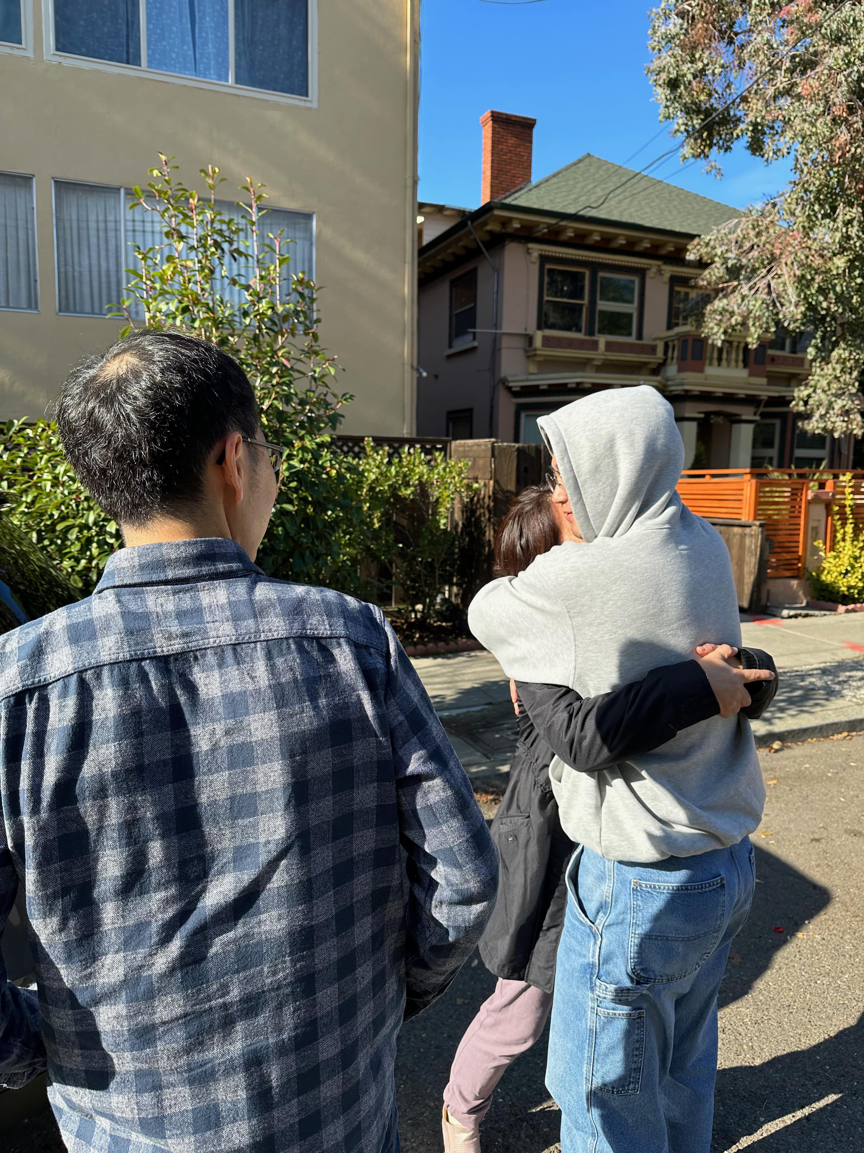 Mom and Bro hugging while Dad watches from the side.